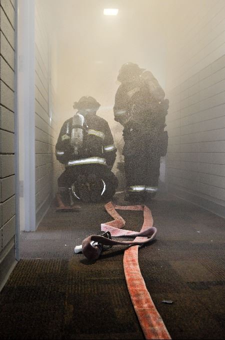 Firefighters with a water hose
