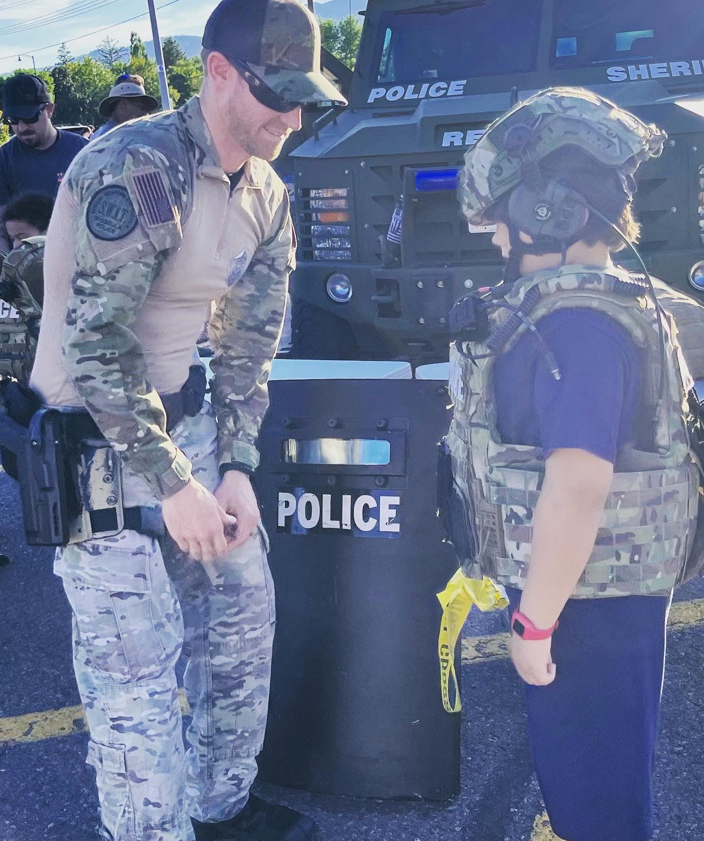 Officer Cameron helping a kid dress in SWAT gear at National Night Out Event 