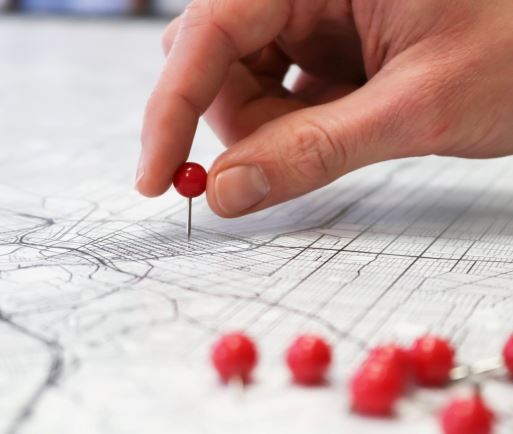 Person putting pins in a map